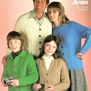 May include: A family of four wearing knitted sweaters in various colors, including white, blue, green, and brown. The sweaters feature cable knit patterns. The text "Sunbeam Aran 81-97 cm 32-38 ins" is visible in the top right corner of the image.