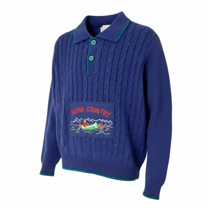 May include: A blue cable-knit sweater with a collared neckline and green trim. The sweater features an embroidered patch with the words "Indian Country" and a canoe scene. The sweater has long sleeves and two green buttons.