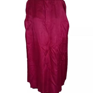 May include: A long, flowing cape in a deep burgundy color. The cape is made of a smooth, shiny fabric and has a scalloped hemline. The cape is displayed on a mannequin.