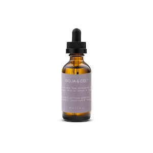 Peut inclure: Un flacon en verre ambré avec un bouchon compte-gouttes noir contenant de l'huile parfumée. L'étiquette est violet clair avec du texte blanc indiquant SOJA & CO., PARFUMÉE POUR DIFFUSEUR, VEGETABLE DIFFUSER SCENTED OIL, Lavender, Sandalwood & Vanilla, 30 ml.