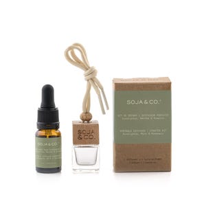 Peut inclure: Un kit de démarrage diffuseur portable Soja & Co. comprenant un flacon en verre ambré de 10 ml avec bouchon compte-gouttes noir, un petit flacon en verre transparent avec bouchon en bois et cordon beige, et une boîte en carton avec étiquette verte.
