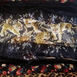 May include: A selection of patterned fabrics with tiger, floral, and leopard designs. The tiger fabric has a black base with yellow and brown tigers. The floral fabric has a black background with red and pink roses. The leopard print is tan and brown.