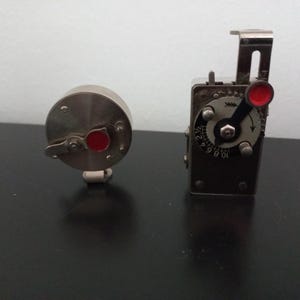 Op de afbeelding: Een witte keramische mok met een zwarte handgreep en de tekst "But First, Coffee" in een vetgedrukte, zwarte letter. De mok staat tegen een vage achtergrond, wat een gezellige setting suggereert.