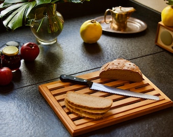 Bread cutting board with breadcrumb compartment