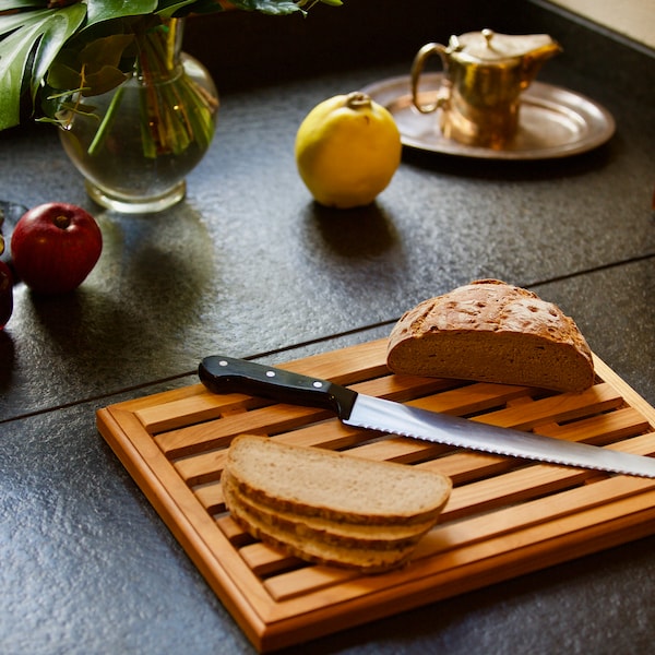 Bread cutting board with breadcrumb compartment