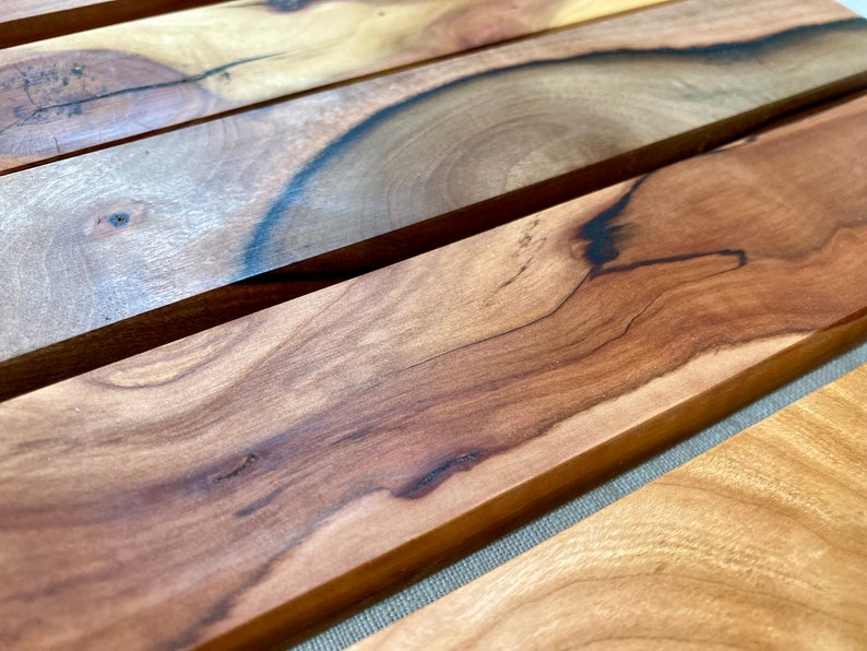 Pu&ograve; includere: Primo piano di una superficie in legno con un motivo a venature del legno naturale. Il legno &egrave; di un colore marrone intenso con venature e nodi pi&ugrave; scuri. La superficie &egrave; liscia e lucida.