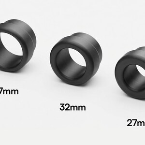 May include: Three black, cylindrical objects with a central hole are displayed against a white background. The objects are labeled with their diameters: 37mm, 32mm, and 27mm. The objects have a smooth, matte finish.