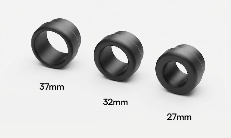 May include: Three black, cylindrical objects with a central hole are displayed against a white background. The objects are labeled with their diameters: 37mm, 32mm, and 27mm. The objects have a smooth, matte finish.