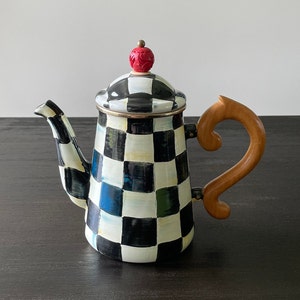 May include: Black and white checkered enamel teapot with a red and gold knob on the lid and a wooden handle.