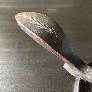 Pu&ograve; includere: Una ciotola di legno con un manico intagliato. Il manico &egrave; decorato con un motivo a foglia intagliato.
