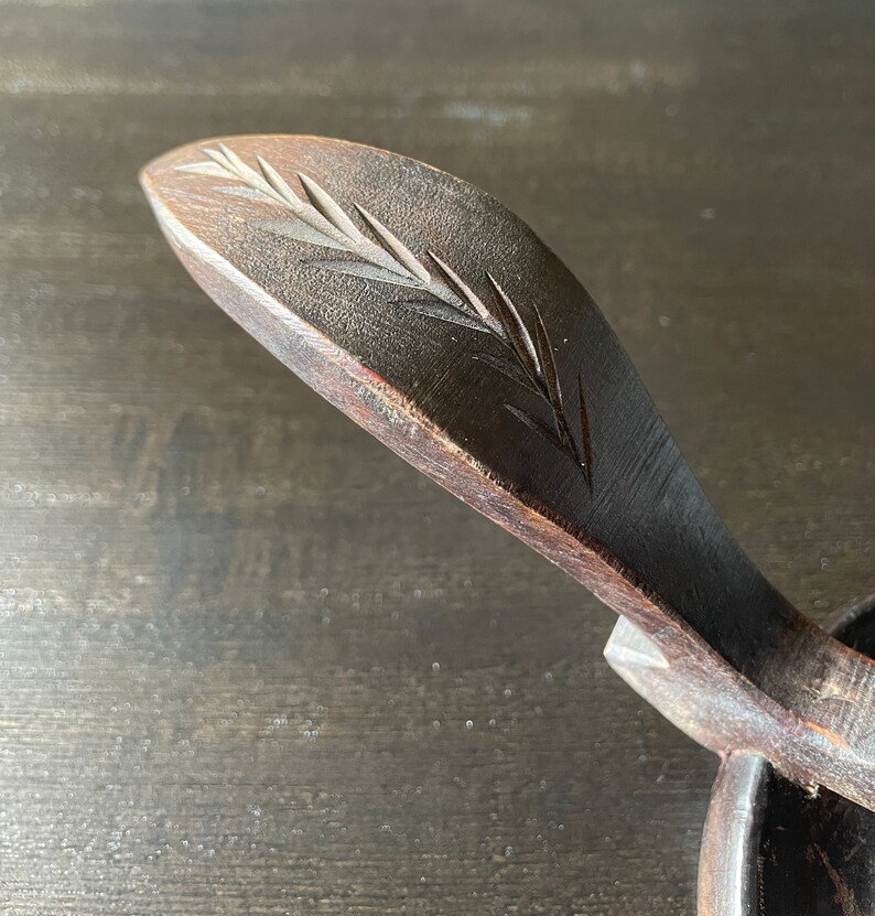 Pu&ograve; includere: Una ciotola di legno con un manico intagliato. Il manico &egrave; decorato con un motivo a foglia intagliato.