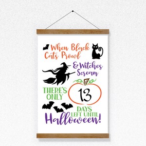 May include: A white sign with a black cat, witch, and bats. The sign says "When black cats prowl & witches scream there's only 13 days left until Halloween!"