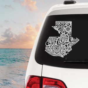 May include: White car decal with a detailed outline of Guatemala and the word "Guatemala" in a stylized font.