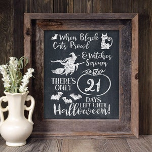May include: A framed chalkboard sign with a Halloween countdown. The sign reads "When black cats prowl & witches scream there's only 21 days left until Halloween!"