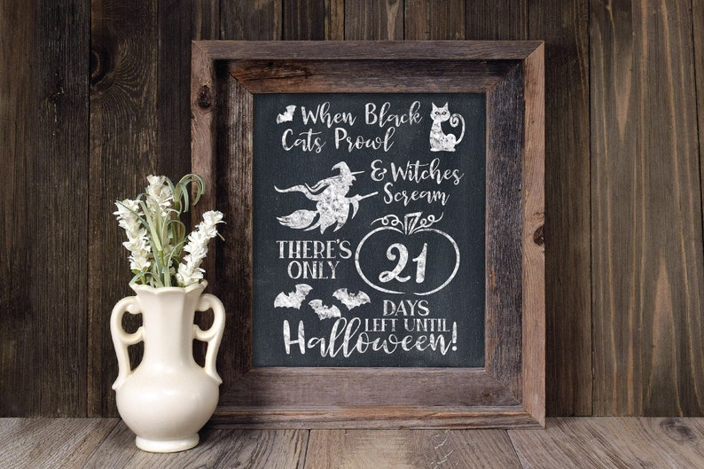 May include: A framed chalkboard sign with a Halloween countdown. The sign reads "When black cats prowl & witches scream there's only 21 days left until Halloween!"