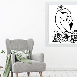 May include: A framed black and white illustration of a flamingo head with a flower crown and floral accents. The artwork is displayed on a white wall above a grey armchair, creating a minimalist aesthetic.