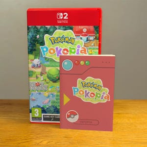 Könnte beinhalten: Ein rotes Nintendo Switch-Spielcase und ein passender rosa Spielkartenhalter. Das Spielcase zeigt den Titel "Pokémon Poképia" mit farbenfrohen Grafiken von Pokémon-Charakteren. Der Spielkartenhalter zeigt ebenfalls den Spieltitel und ein Pokéball-Symbol.