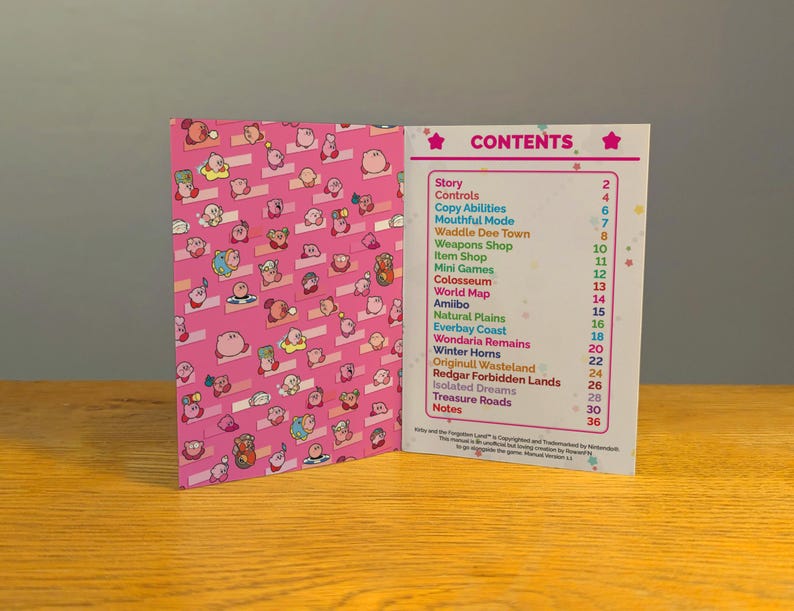 May include: A pink and white booklet with the title "CONTENTS" and a list of game features for the video game Kirby and the Forgotten Land. The cover of the booklet features a pink background with a pattern of Kirby characters.