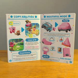 May include: A pink and blue illustrated guide to the Mouthful Mode in the Kirby video game. The guide shows Kirby swallowing and digesting different objects, including a car, a traffic cone, and a pink triangle. The text on the page reads "Mouthful Mode" and "Kirby".