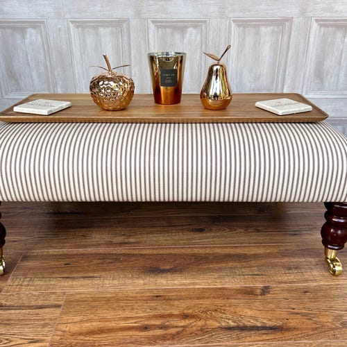 Grand repose-pieds rembourré en tissu coutil Table basse dans un grand repose-pieds à rayures. Grand pouf en tissu coutil sur pieds à roulettes