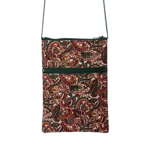 May include: A small paisley patterned crossbody bag with a green strap and two zipper closures.