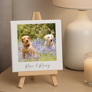 May include: A square ceramic tile with a photograph of two dogs in a field of purple flowers, displayed on a small wooden easel. The tile has the text "Max & Missy" in a handwritten font.
