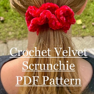 May include: A bright red velvet scrunchie is worn in a ponytail. The scrunchie is made of a soft, plush material and is gathered to create a full, textured look. Text on the image reads "Crochet Velvet Scrunchie PDF Pattern."