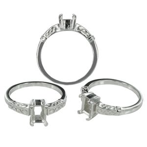 Puede incluir: Tres monturas de anillo plateadas dispuestas en formación triangular. Cada anillo presenta un engaste de garras rectangular diseñado para sostener una piedra preciosa, complementado con una banda decorada con un patrón de volutas en relieve.