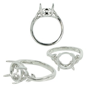 May include: Silver ring setting with a round bezel and leaf accents. The setting is designed to hold a gemstone.