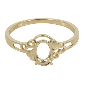 May include: A gold ring with an oval-shaped setting for a gemstone. The ring has a delicate, ornate design with a floral motif.