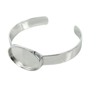 May include: Silver bangle bracelet with an oval-shaped bezel for a cameo or other embellishment.