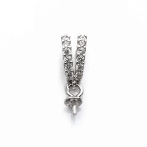 May include: A silver pendant bail with a V-shaped design. The bail is set with small, clear gemstones. It has a loop and a peg for attaching a pendant or bead. The background is plain white.