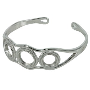 May include: Silver bangle bracelet with three open circles, each with a textured edge.