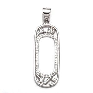 Peut inclure: Pendentif en argent avec un délicat motif floral et un cadre rectangulaire. Le pendentif a une finition lisse et polie.