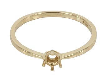 Puede incluir: Un anillo de oro con engaste de garras para una piedra preciosa. El anillo es simple y elegante.