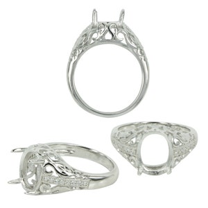 May include: Silver ring setting with a filigree design and a bezel for a large oval gemstone. The ring has small clear stones set around the bezel.