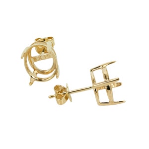 May include: A pair of gold-tone earring settings with a round bezel. The settings are designed to hold a stone or gem. The back of the earring is a post with a butterfly clasp.