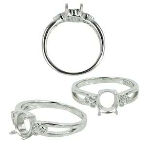 May include: Silver ring with an oval-shaped setting and four small round stones. The ring is marked with the number "S265".