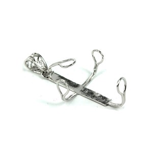 May include: Silver-toned metal pendant with a cross design and a bail for attaching a chain. The cross has a decorative filigree pattern and is designed to hold a round cabochon stone.