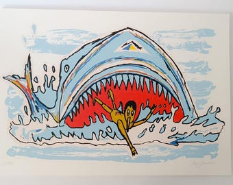 May include: A colourful screen print of a shark with its mouth open, swallowing a person. The shark is blue, white and yellow, and the person is yellow, red and black. The background is light blue.