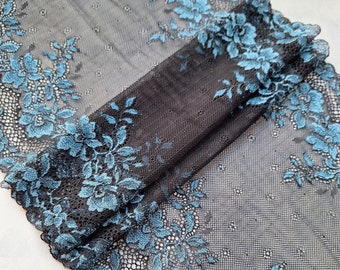 Könnte beinhalten: Schwarzer Spitzenstoff mit einem türkisfarbenen Blumenmuster. Die Spitze ist zart und hat eine weiche, fließende Textur.
