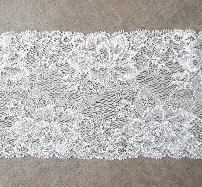 May include: White lace trim with a floral pattern.
