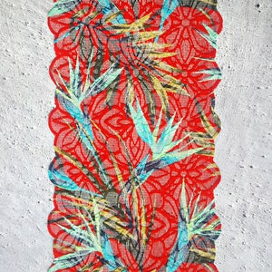 May include: Red lace trim with a floral pattern featuring blue, green, and yellow leaves. The lace has a scalloped edge.