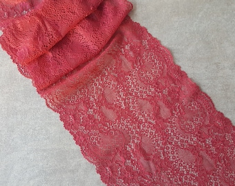 Puede incluir: Borde de encaje rojo con un delicado patrón floral. El encaje es suave y tiene una apariencia ligeramente transparente.