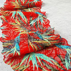 May include: Red lace trim with a tropical leaf pattern in shades of green, yellow, and blue.