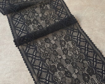 May include: Black lace trim with a delicate floral pattern. The trim is approximately 1 inch wide and has a scalloped edge.