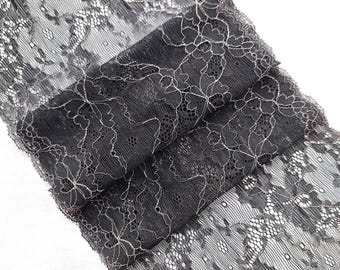 May include: Black lace trim with a delicate floral pattern and a subtle shimmer. The lace is soft and flexible, making it ideal for adding a touch of elegance to any project.