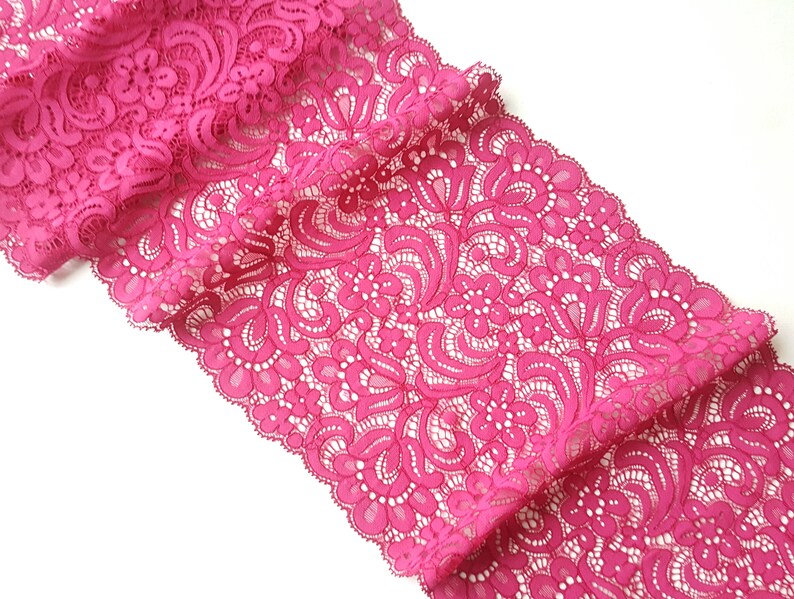 May include: Pink lace trim with a floral pattern.