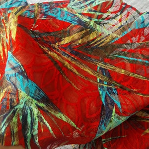 May include: Red mesh fabric with a tropical leaf print in shades of green, blue, and gold.