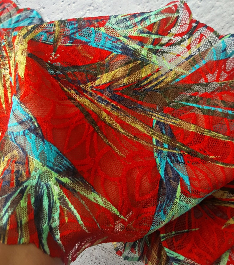 May include: Red mesh fabric with a tropical leaf print in shades of green, blue, and gold.